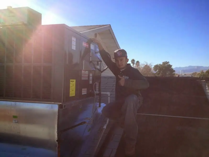 HVAC technician performing HVAC Inspection on a rooftop unit in Syracuse